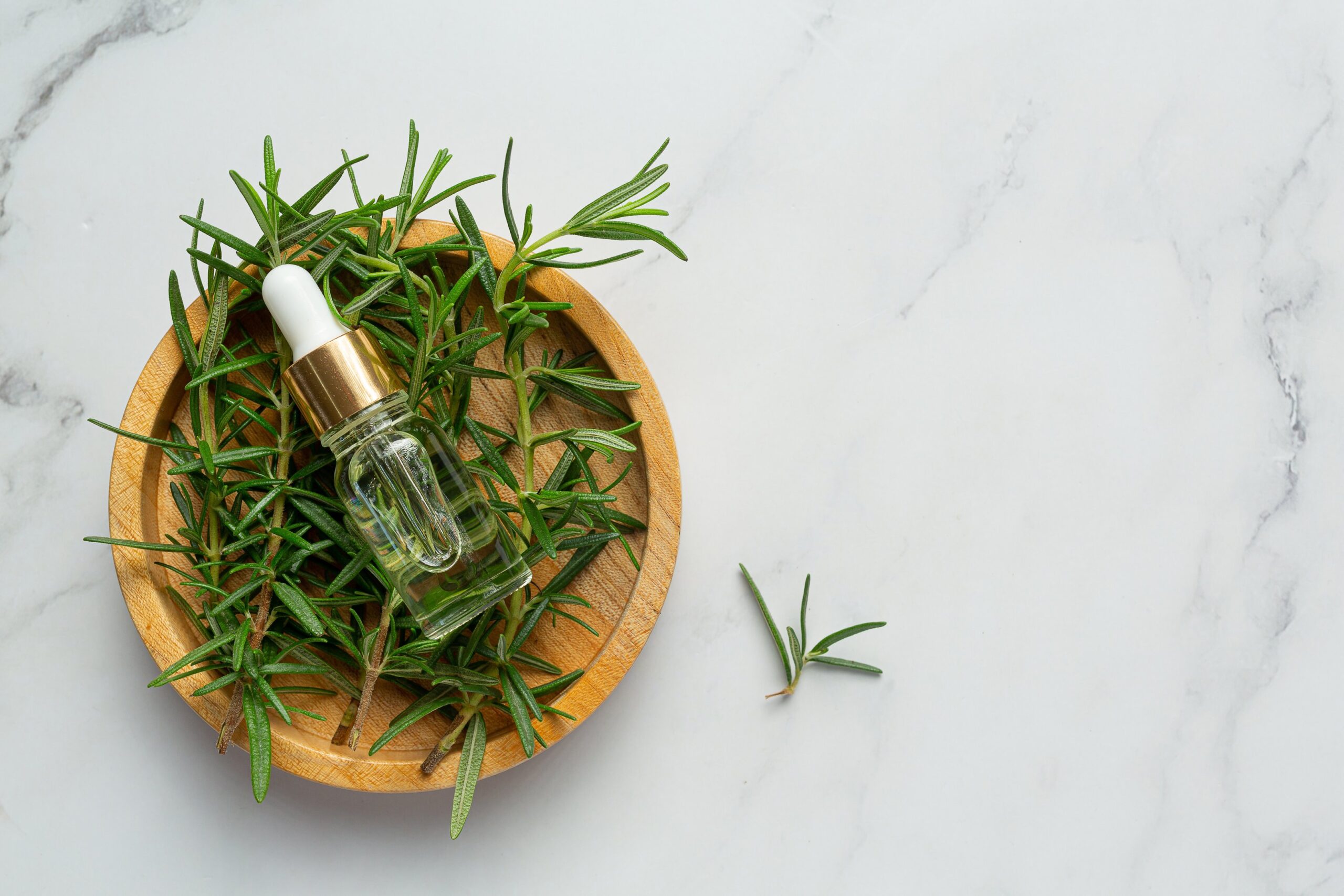 Flat lay of organic skincare products with dropper bottles and herbs.